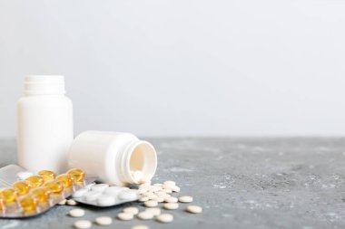 Medicine for treatment HIV infection. Pills and capsules and battle on the table. Different colorful tablets at colored background with copy space.