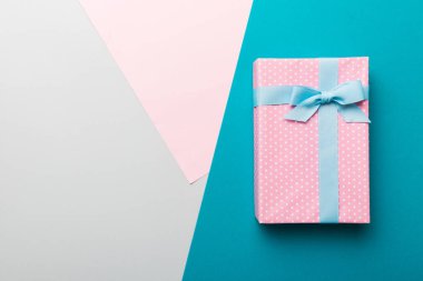 holiday handmade paper present tied blue ribbon bow top view with copy space. Flat lay holiday background. Birthday or christmas present. Christmas gift box concept with copy space.