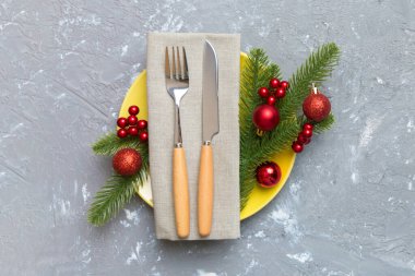 Noel süsleri, tabaklar, inekler, çatallar ve kaşıklarla Noel sofrası. Noel tatili geçmişi. Kopyalama alanı olan üst görünüm.