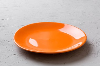 Çimento arka planındaki boş turuncu plakanın perspektif görüntüsü. Tasarımın için boş boşluk.