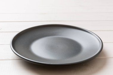 Ahşap zemindeki boş siyah plakanın perspektif görüntüsü. Tasarımın için boş boşluk.