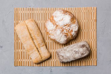 Kırsal masa manzaralı peçeteli taze pişmiş ekmek çeşitleri. Sağlıklı mayasız ekmek. Fransız ekmeği.