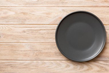 Ahşap arka plandaki siyah plakanın üst görüntüsü. Tasarımın için boş boşluk.