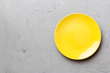 Çimento arka planındaki boş sarı plakanın üst görüntüsü. Tasarımın için boş boşluk.