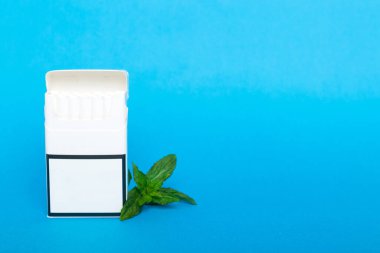 Bir paket mentollü sigara ve renkli masada taze nane şekeri, mentollü sigaralar düz yerde yatıyordu..