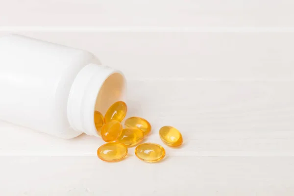 Omega-3 capsules lie in white bottle on a table background. Fish oil tablets top view. Biologically active additives. omega 6, omega 9, vitamin A, E, vitamin D, vitamin D3, evening primrose oil.