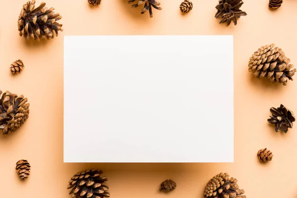 Creative frame made of Christmas pine cones with square Paper blank. Xmas and New Year theme. Flat lay, top view copy space.