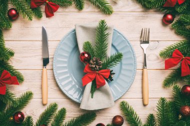 Noel süsleri, tabaklar, inekler, çatallar ve kaşıklarla Noel sofrası. Noel tatili geçmişi. Üst görünüm.