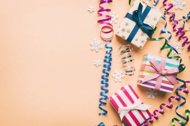 Renkli kağıda sarılı ve renkli arka planda konfetiyle süslenmiş hediye kutularıyla tatil dairesi yatıyordu. Noel, Doğum günü, Sevgililer Günü ve satış konsepti, üst manzara.