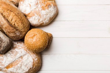 Ev yapımı doğal ekmek. Arka plan olarak farklı taze ekmek türleri, kopya alanı ile üst görünüm.