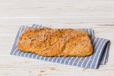 Kırsal masa manzaralı peçeteli taze pişmiş ekmek çeşitleri. Sağlıklı mayasız ekmek. Fransız ekmeği.