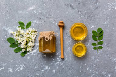 Akasya çiçekli ve yapraklı bal kavanozu. Taze bal üst görünüm düz yatıyordu.