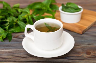 Arka planda bir fincan nane çayı. Fotokopi alanı ile taze nane görünümlü yeşil çay.