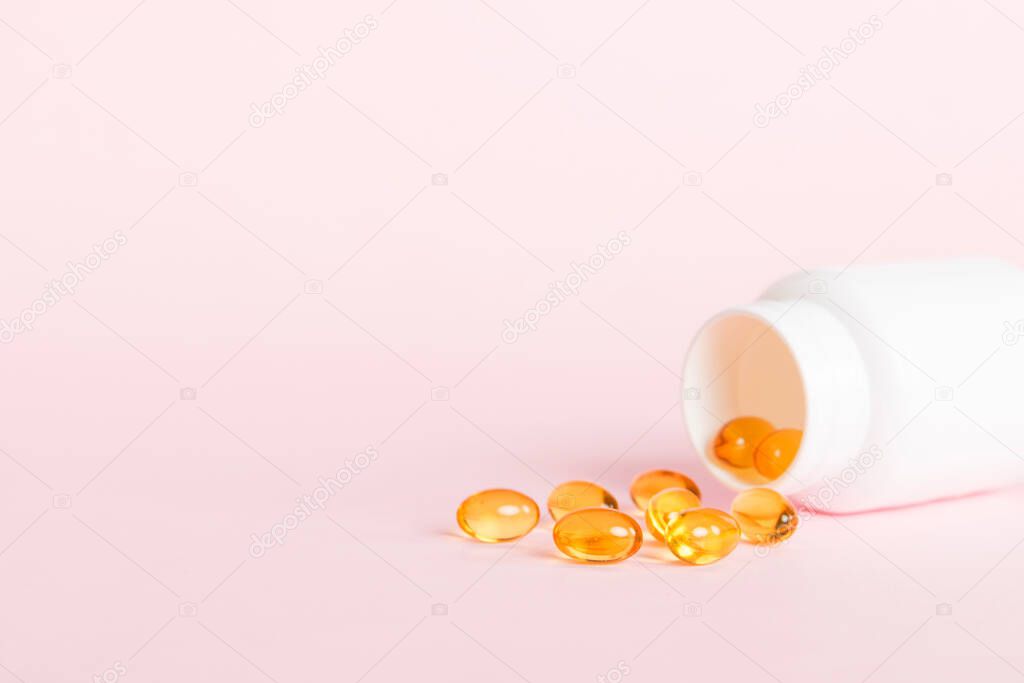 Soft gels pills with Omega-3 oil spilling out of pill bottle close-up. Gel capsules bottle white surface. Omega 3, multivitamins, Calcium, antibiotics. Health. Immunity.