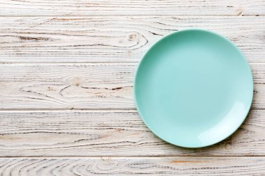 Ahşap zemindeki boş mavi tabağın üst görüntüsü. Tasarımın için boş boşluk.