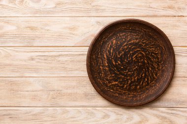 Ahşap zemindeki boş tabağın üst görünümü. Tasarımın için boş boşluk.