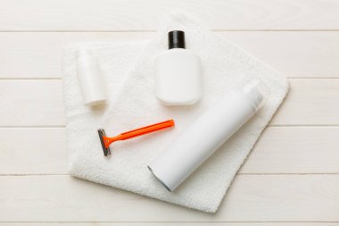 Tıraş Adam seti. Traş makinesi, havlu, losyon ve renkli arka planda tıraş köpüğü. Erkekler banyo aksesuarları üst görünüm.