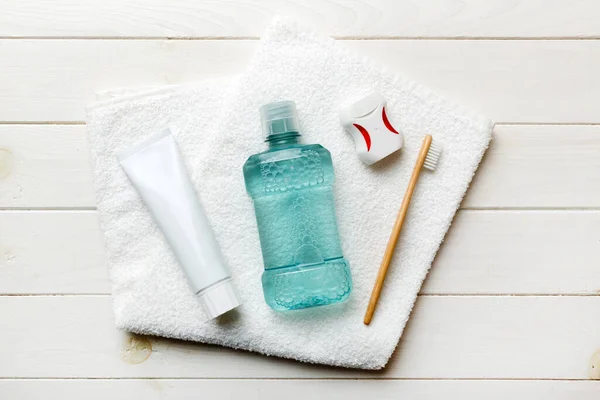 Mouthwash and other oral hygiene products on colored table top view with copy space. Flat lay. Dental hygiene. Oral care products and space for text on light background. concept.