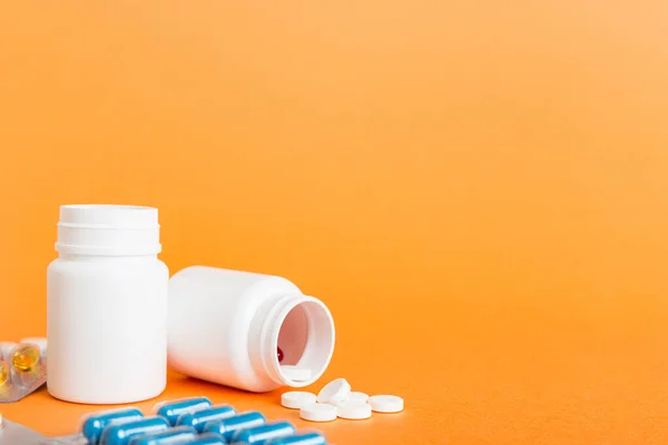 Medicine for treatment HIV infection. Pills and capsules and battle on the table. Different colorful tablets at colored background with copy space.