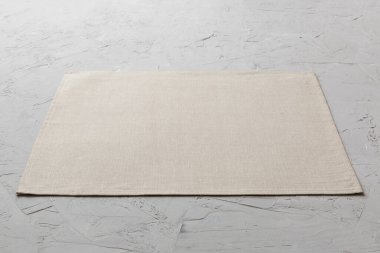 Çimento arka planındaki yemek için gri masa örtüsünün perspektif görüntüsü. Tasarımın için boş boşluk.