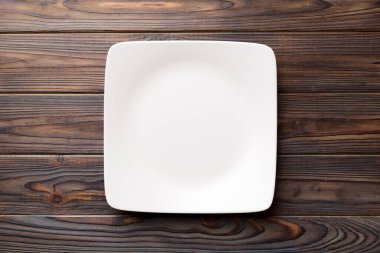 Ahşap zemin üzerinde boş kare plakanın üst görünümü. Tasarımın için boş boşluk.