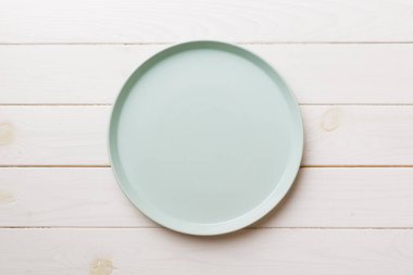 Ahşap zemindeki boş mavi tabağın üst görüntüsü. Tasarımın için boş boşluk.