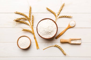 Tahta kasede buğday unu ve renkli arka planda buğday dikenleri. dünya buğday krizi.