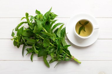 Arka planda bir fincan nane çayı. Fotokopi alanı ile taze nane görünümlü yeşil çay.