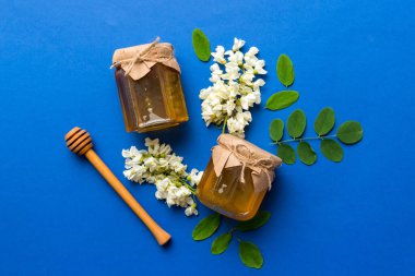 Akasya çiçekli ve yapraklı bal kavanozu. Taze bal üst görünüm düz yatıyordu.