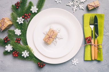 Noel süsleri, tabaklar, inekler, çatallar ve kaşıklarla Noel sofrası. Noel tatili geçmişi. Üst görünüm.