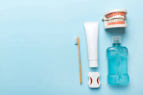 Mouthwash and other oral hygiene products on colored table top view with copy space. Flat lay. Dental hygiene. Oral care kit. Dentist concept.