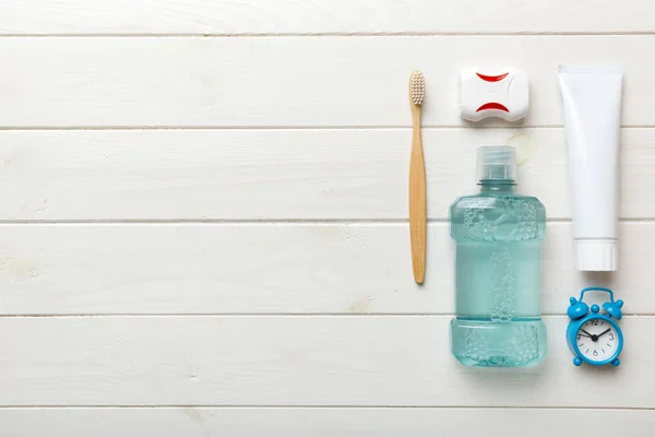 Mouthwash and other oral hygiene products on colored table top view with copy space. Flat lay. Dental hygiene. Oral care products and space for text on light background. concept.