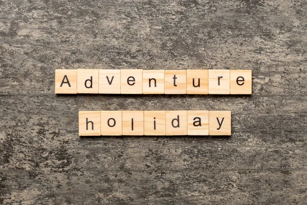 adventure holiday word written on wood block. adventure holiday text on cement table for your desing, concept.