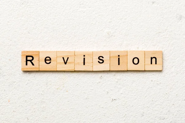revision word written on wood block. revision text on table, concept.