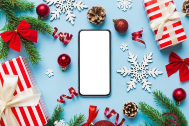 Digital phone mock up with rustic Christmas decorations for app presentation top view with empty space for you design. Christmas online shopping concept. Tablet with copy space on colored background.