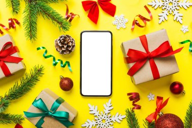 Digital phone mock up with rustic Christmas decorations for app presentation top view with empty space for you design. Christmas online shopping concept. Tablet with copy space on colored background.