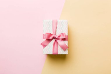 holiday paper present tied pink ribbon bow top view with copy space. Flat lay holiday background. Birthday or christmas present. Christmas gift box concept with copy space.