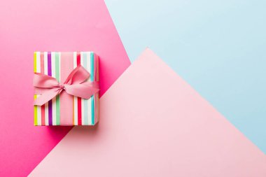 holiday paper present tied pink ribbon bow top view with copy space. Flat lay holiday background. Birthday or christmas present. Christmas gift box concept with copy space.