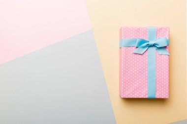 holiday handmade paper present tied blue ribbon bow top view with copy space. Flat lay holiday background. Birthday or christmas present. Christmas gift box concept with copy space.