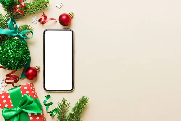 Digital phone mock up with rustic Christmas decorations for app presentation top view with empty space for you design. Christmas online shopping concept. Tablet with copy space on colored background.