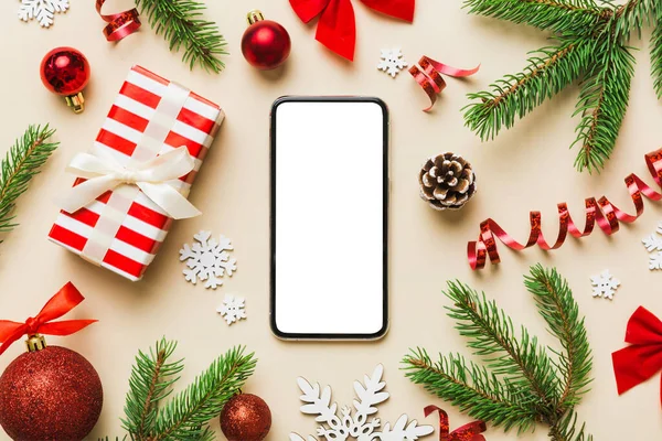 Digital phone mock up with rustic Christmas decorations for app presentation top view with empty space for you design. Christmas online shopping concept. Tablet with copy space on colored background.