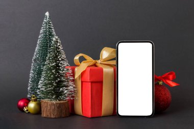 Digital phone mock up with rustic Christmas decorations for app presentation with empty space for you design. Christmas online shopping concept. Tablet with copy space on colored background.