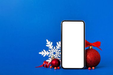 Digital phone mock up with rustic Christmas decorations for app presentation with empty space for you design. Christmas online shopping concept. Tablet with copy space on colored background.
