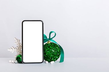 Digital phone mock up with rustic Christmas decorations for app presentation with empty space for you design. Christmas online shopping concept. Tablet with copy space on colored background.