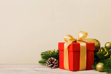 New Year Christmas mood, gift box, branches of a christmas tree, New Year decorations on a colored background.