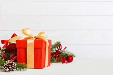 New Year Christmas mood, gift box, branches of a christmas tree, New Year decorations on a colored background.