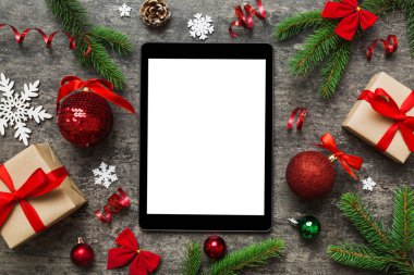 Digital tablet mock up with rustic Christmas decorations for app presentation top view with empty space for you design. Christmas online shopping concept. Tablet with copy space on colored background.