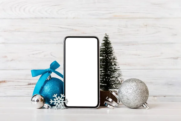 Digital phone mock up with rustic Christmas decorations for app presentation with empty space for you design. Christmas online shopping concept. Tablet with copy space on colored background.