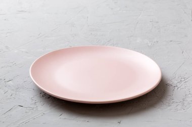 Çimento arka planında boş pembe plaka manzarası. Tasarımın için boş boşluk.