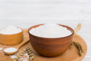 Tahta kasede buğday unu ve renkli arka planda buğday dikenleri. dünya buğday krizi.